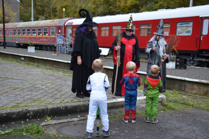 a group of people standing next to a train