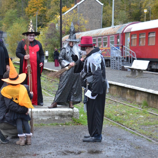 a group of people standing next to a train