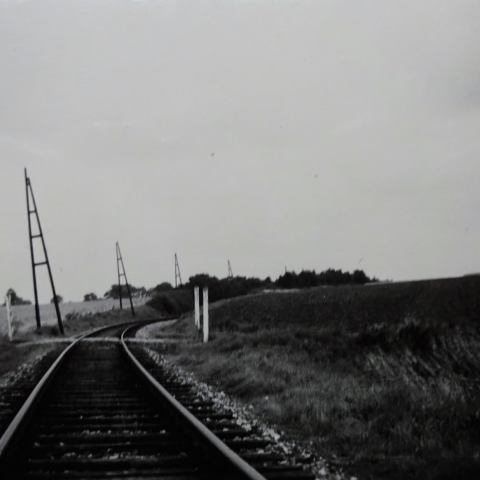 a train traveling down train tracks near a field