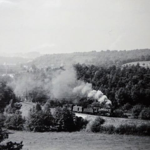a steam train on a track with smoke coming out of it