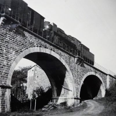 a large brick building with a bridge in the background