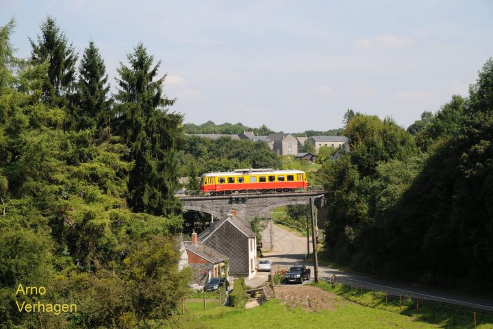a train traveling down train tracks next to a tree