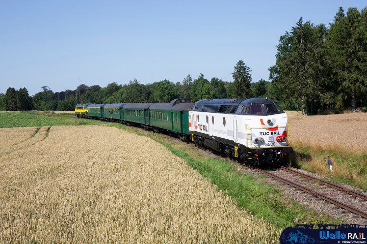 a train traveling down train tracks near a field