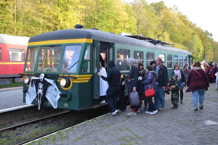 a group of people standing next to a train