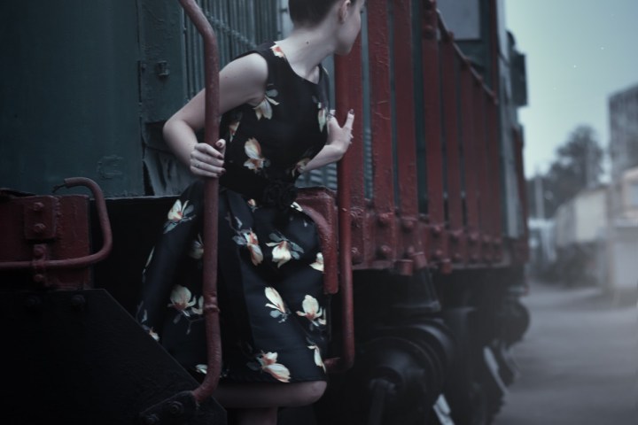 a person sitting on a bench in front of a building