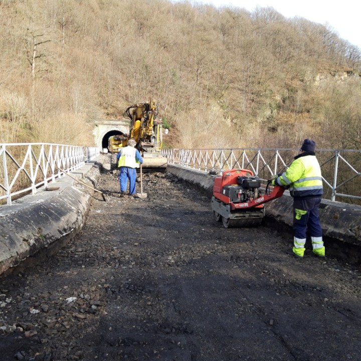 a man riding a bike down a dirt road