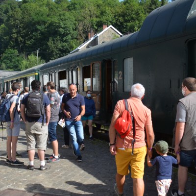 a group of people standing next to a train