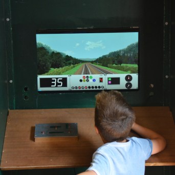 a young boy standing in front of a television