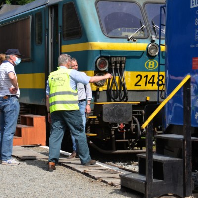 a group of people standing next to a train
