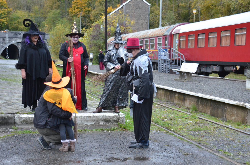 a group of people standing next to a train