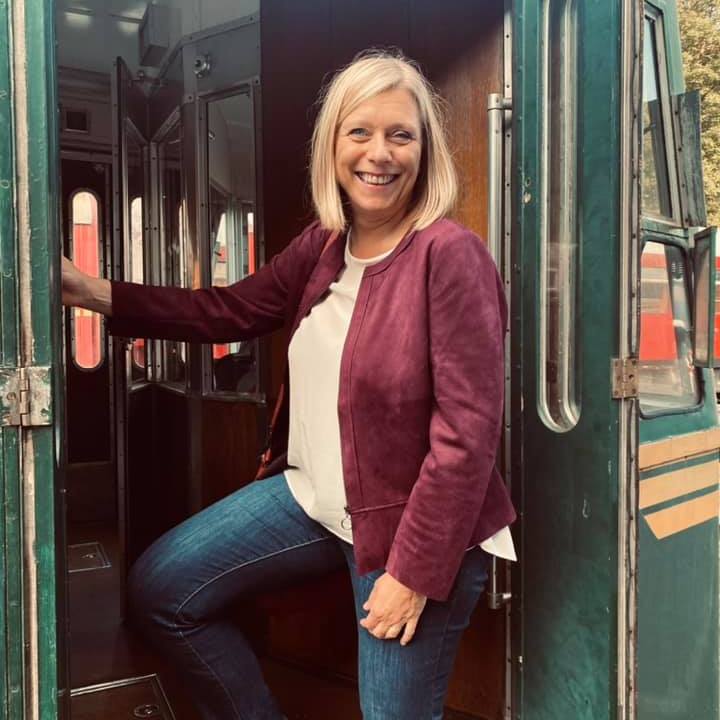 a woman standing in front of a bus