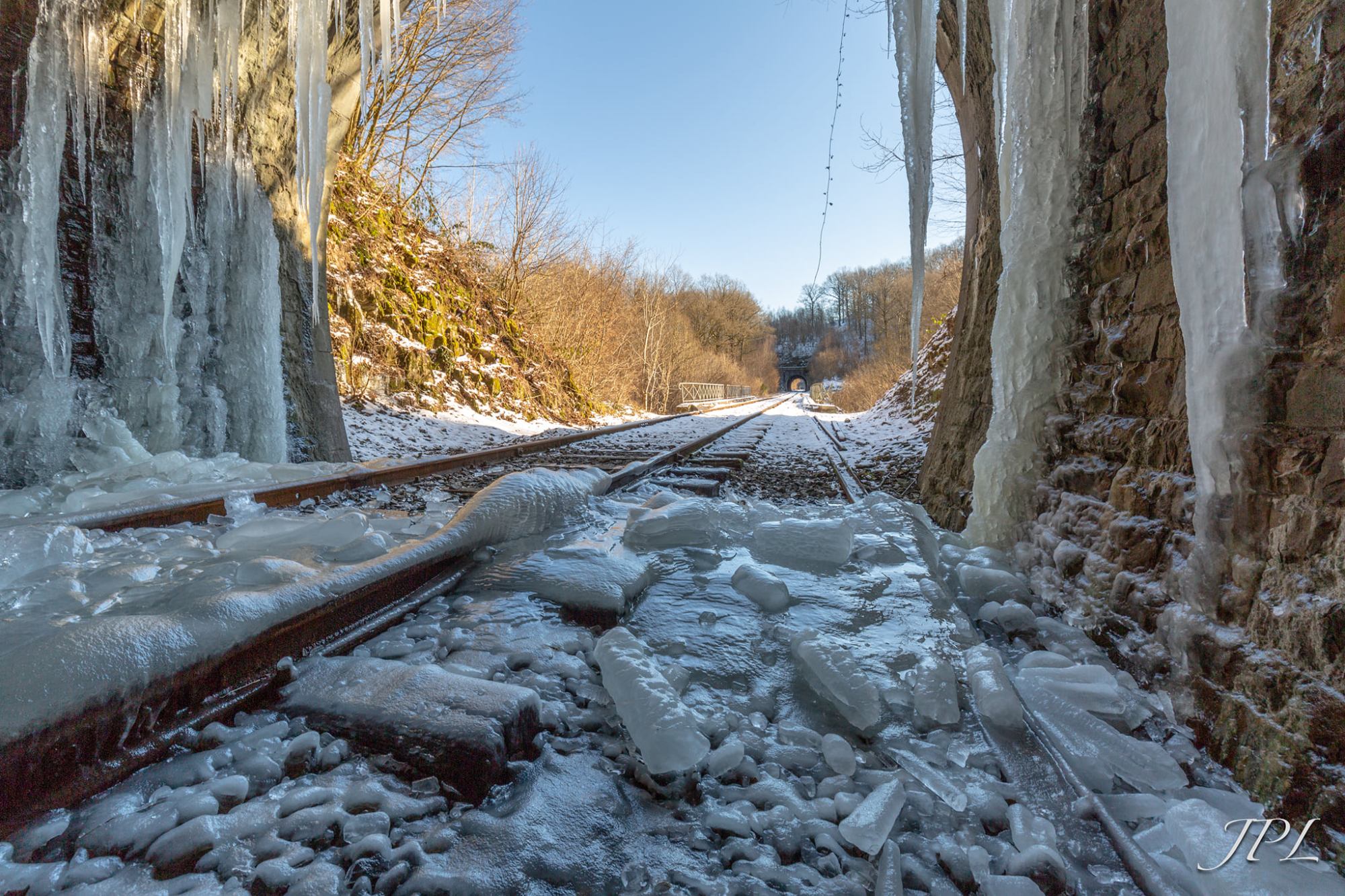 a pile of snow next to a waterfall