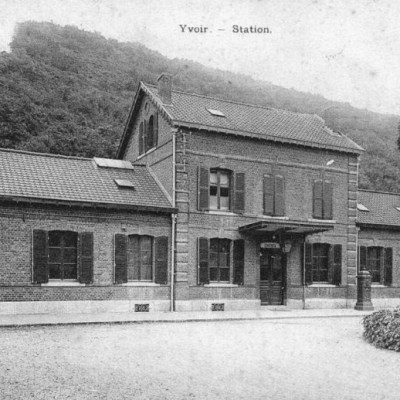an old brick house with trees in the background