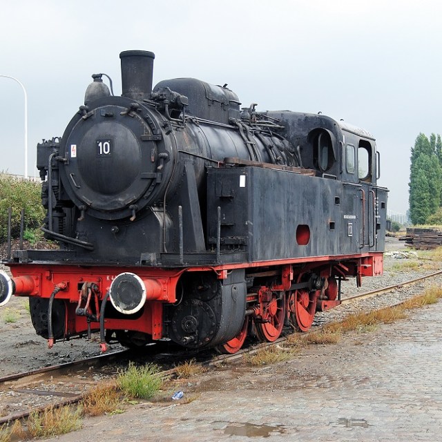 a steam engine is sitting on a train track