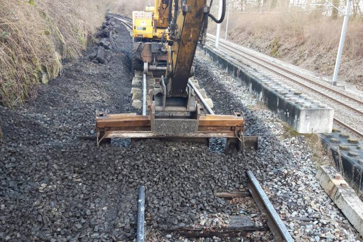 a train traveling down train tracks near a forest