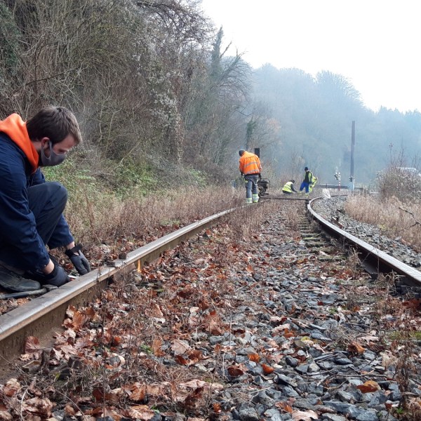 a group of people on a train track with trees in the background