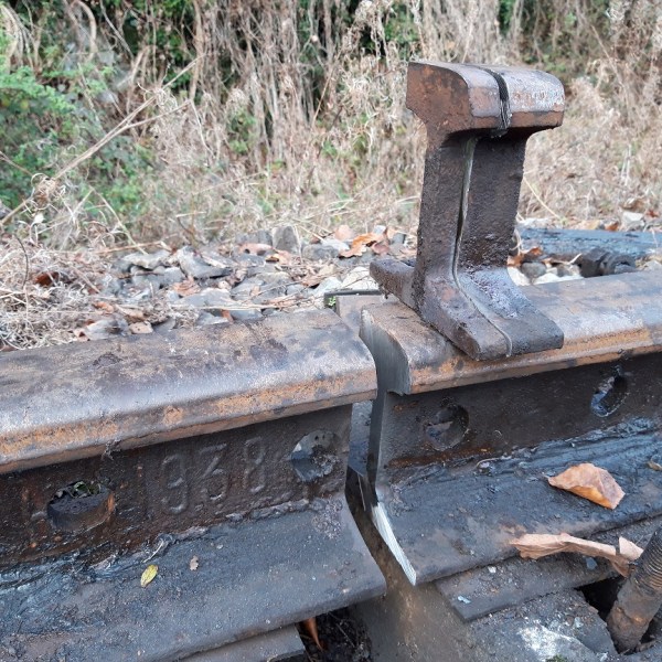 a wooden bench sitting next to a stone wall