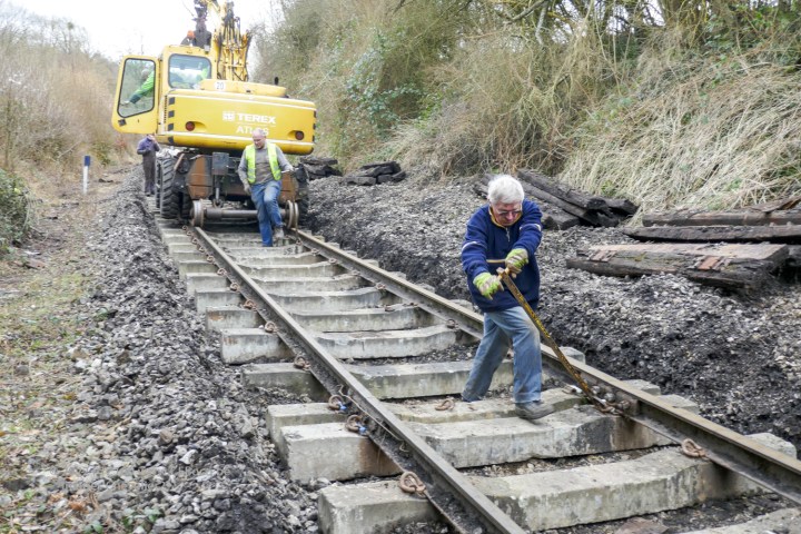a person sitting on a train track with trees in the background