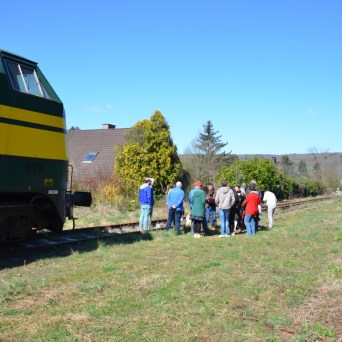 a group of people in a field next to a train