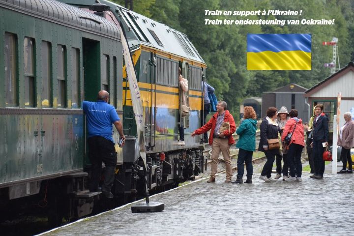 a group of people standing next to a train