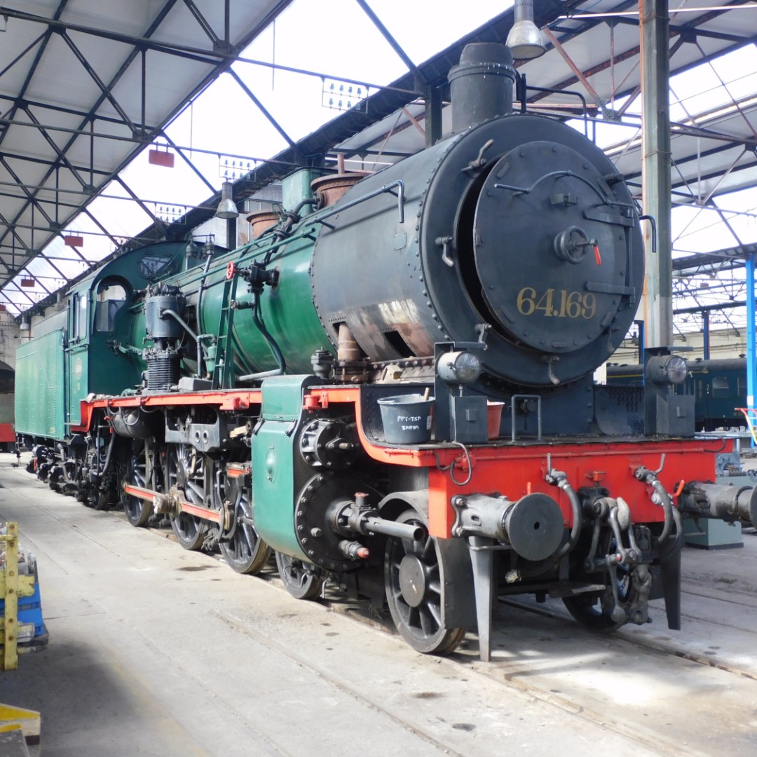 a person sitting at a train station with National Railway Museum in the background
