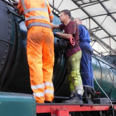 a man standing next to a car engine