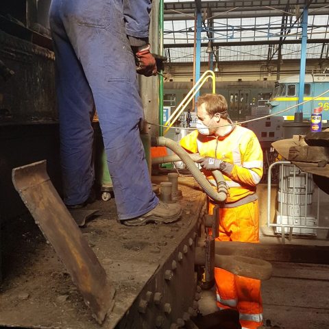 a person cooking hot dogs on a grill
