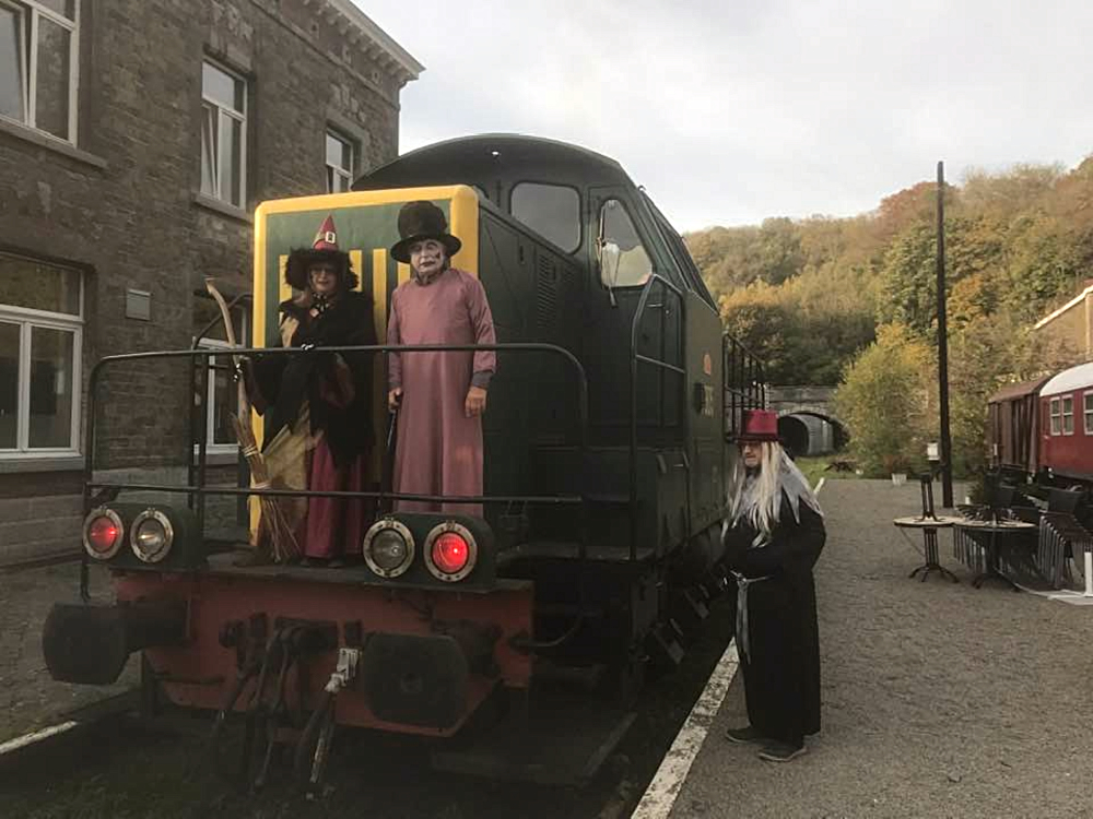 a group of people standing next to a train