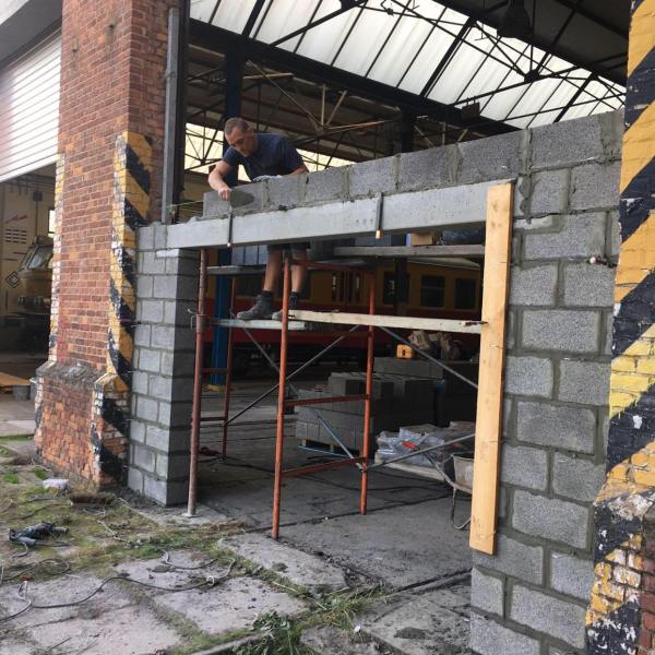 a group of people standing in front of a brick building