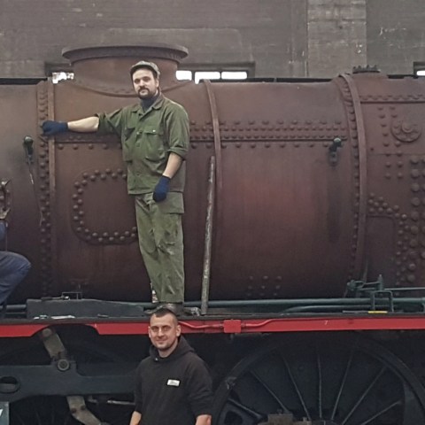 a man standing in front of a military vehicle