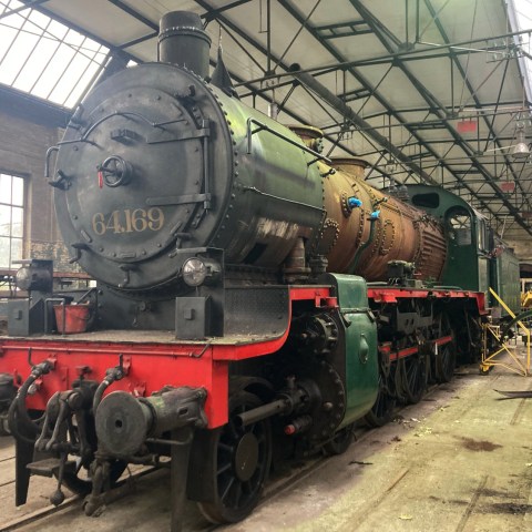 a steam engine is sitting on a train track