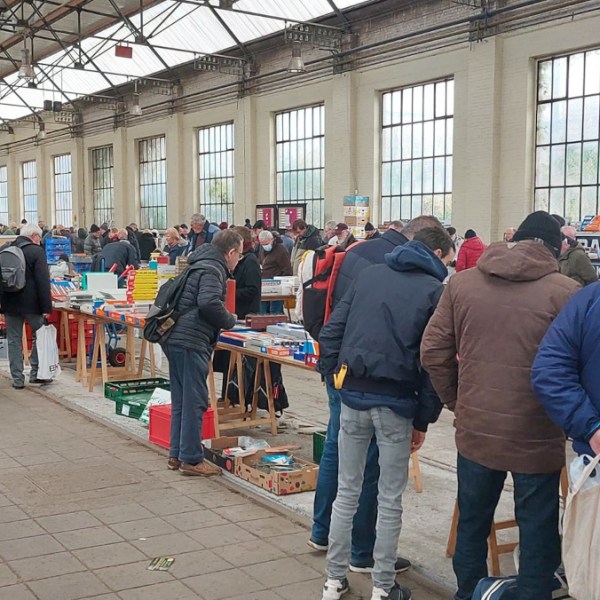 a group of people waiting for their luggage at an airport