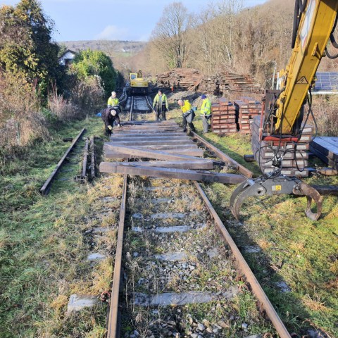a group of people on a train track with trees in the background