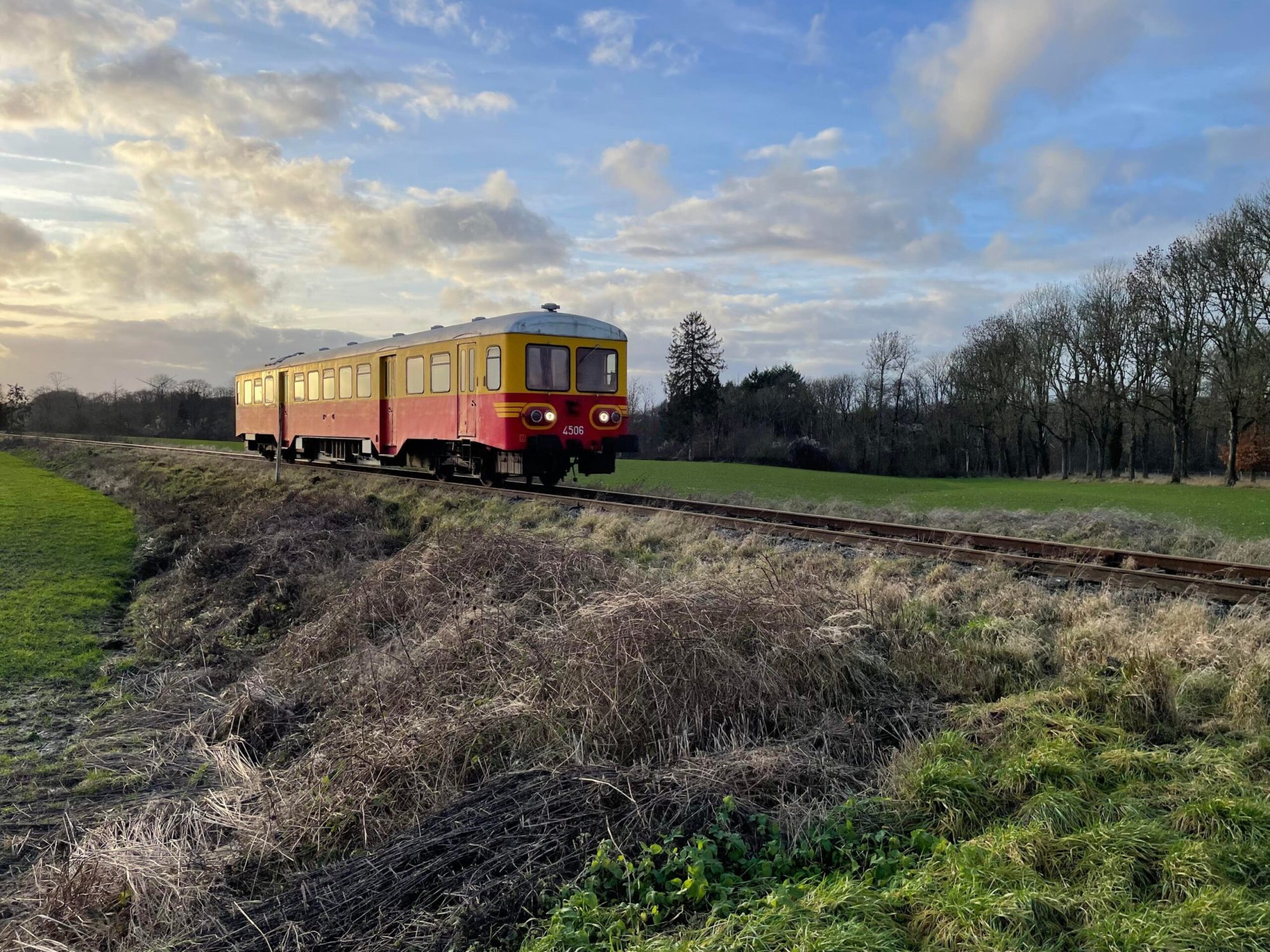 a train traveling down train tracks near a field