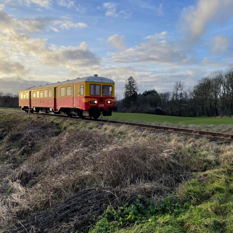 a train traveling down train tracks near a field