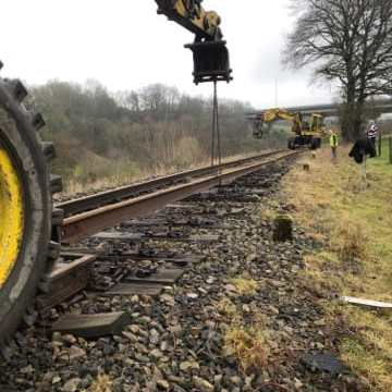 a train is parked on a dirt track
