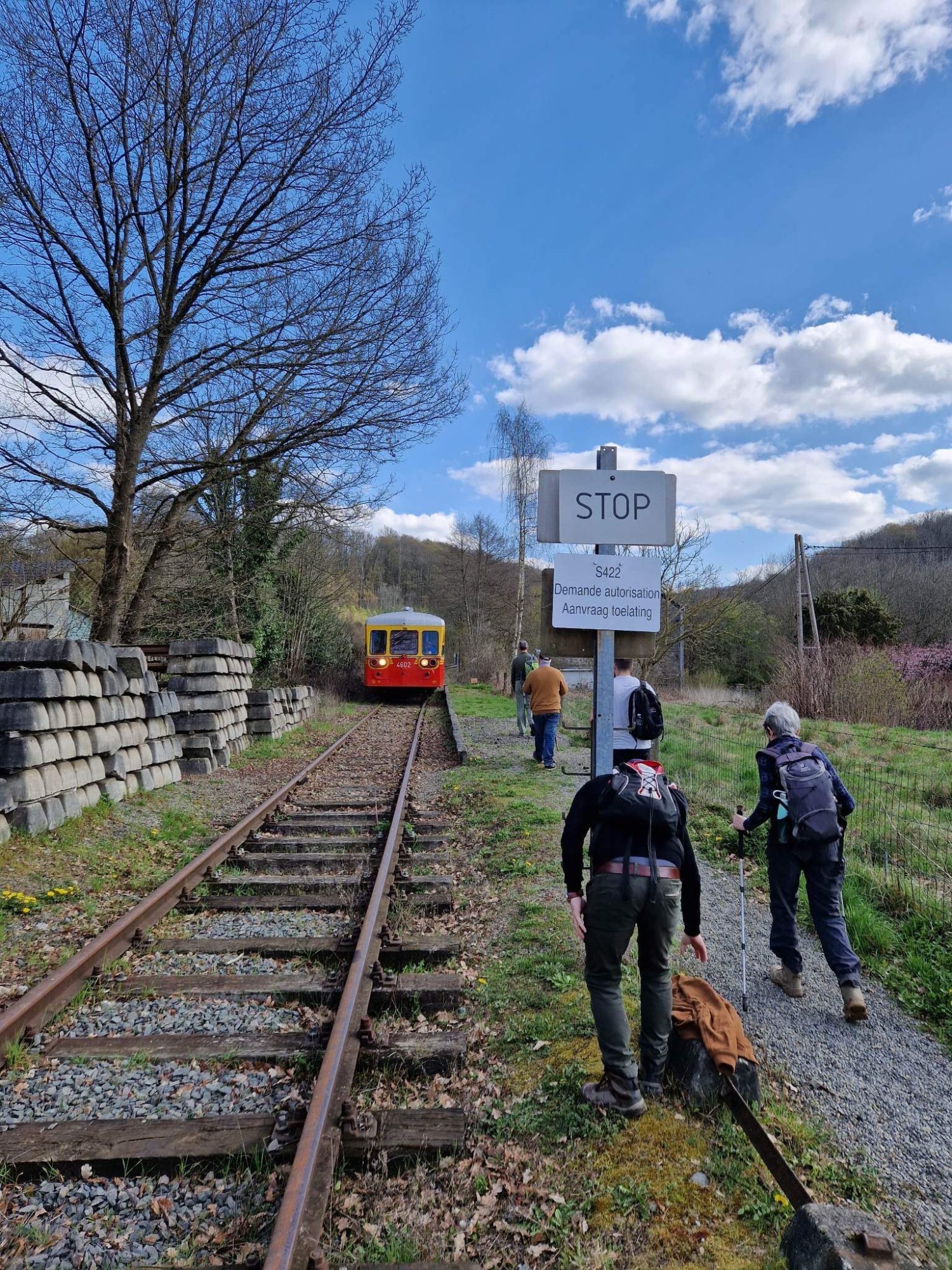 a group of people on a train track with trees in the background
