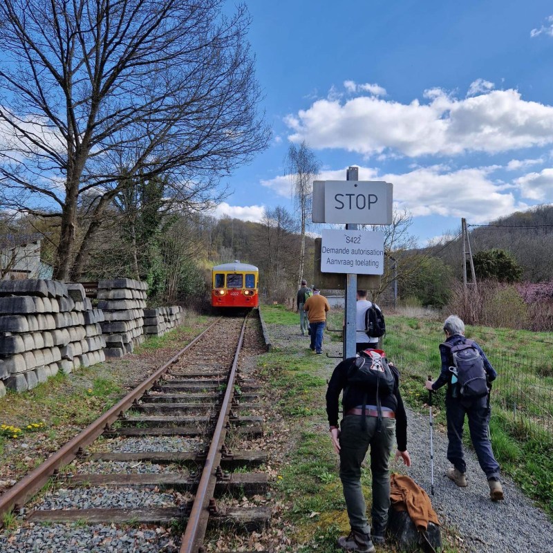 a group of people on a train track with trees in the background