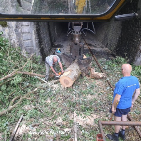 a man sitting on top of a wooden fence