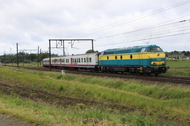a train traveling down train tracks near a field